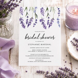 May include: A white rectangular bridal shower invitation card featuring a watercolor illustration of purple lavender sprigs at the top. The text reads: Please join us for a bridal shower in honor of Stephanie Marshal, Saturday, March 14th at 3:00pm.