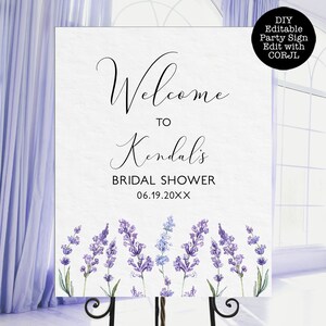 May include: A white welcome sign with lavender floral accents. The sign reads "Welcome to Kendall's Bridal Shower 06.19.20XX".