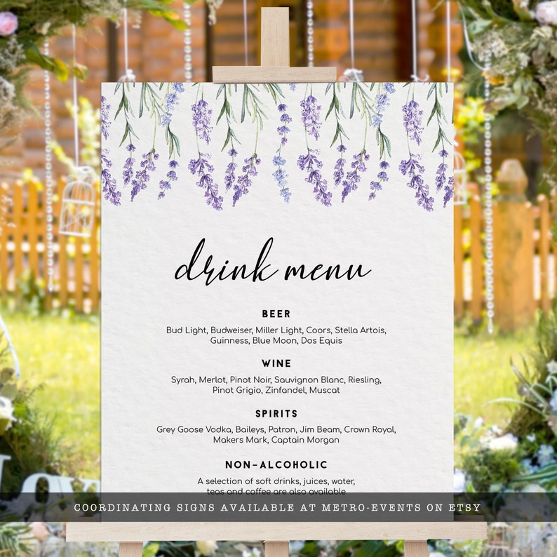 Op de afbeelding: Een printbaar drankmenu-bord met een lavendelbloemendesign. Het menu bevat bier, wijn, sterke drank en alcoholvrije opties. De tekst "COORDINATING SIGNS AVAILABLE AT METRO-EVENTS ON ETSY" staat onderaan.