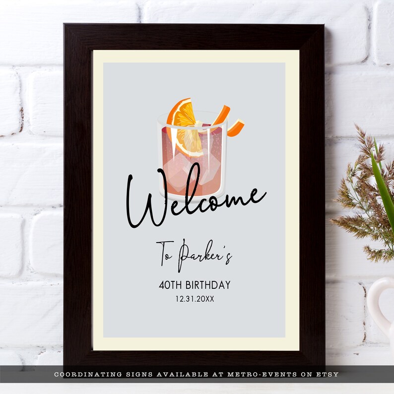 Minimalist Cocktail Party Welcome Sign. A classy cocktail glass garnished with an orange and retro typography. Designed by MetroEvents.