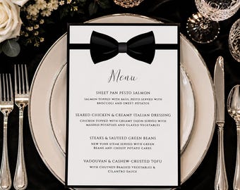 May include: A rectangular white menu card featuring a black bow tie graphic at the top. The text lists food items including sheet pan pesto salmon, seared chicken with creamy Italian dressing, steaks with sauteed green beans, and vadouvan cashew-crusted tofu.