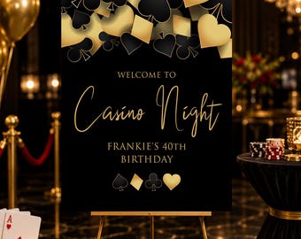 May include: A black rectangular sign on a gold easel featuring gold and black playing card suit symbols at the top and bottom. The text reads: WELCOME TO Casino Night FRANKIE'S 40TH BIRTHDAY in gold lettering against a solid black background.