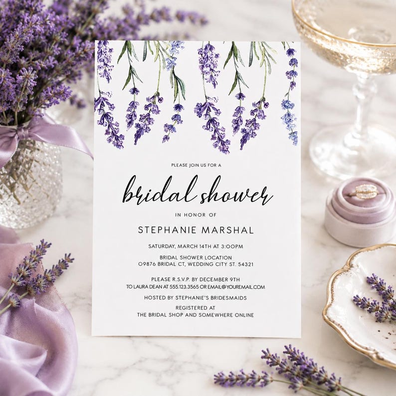 May include: A white rectangular bridal shower invitation card featuring a watercolor illustration of purple lavender sprigs at the top. The text reads: Please join us for a bridal shower in honor of Stephanie Marshal, Saturday, March 14th at 3:00PM.