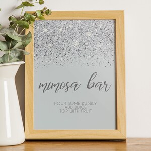 Sparkling Silver Glitter Mimosa Bar Sign and Tags. A glam style sign is created with faux silver glitter on a coordinating silver background with elegant text. Designed By MetroEvents.