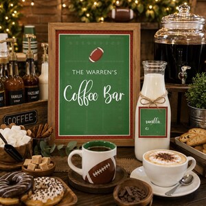 May include: A framed sign with a green football field background and the text THE WARREN'S Coffee Bar, featuring a football graphic. The sign is displayed alongside a coffee mug with a football design, a milk bottle, and various coffee bar items.