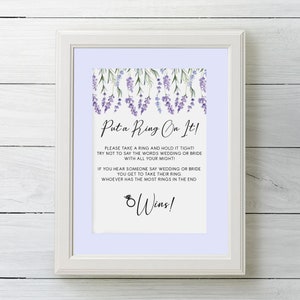 Op de afbeelding: Een lavendel-thema spelkaart met de tekst "Put a Ring On It!" en instructies voor een huwelijksspel. De kaart heeft een paarse achtergrond met een bloemige rand.