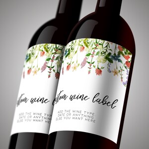 K&ouml;nnte beinhalten: Zwei dunkle Weinflaschen aus Glas mit wei&szlig;en Etiketten, die oben ein florales Aquarellmotiv aufweisen. Die Etiketten zeigen den schwarzen kursiven Text "custom wine label" und den Blocktext "ADD THE WINE TYPE, DATE OR ANYTHING ELSE YOU WANT HERE".
