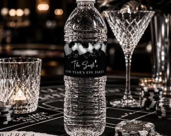 May include: A clear plastic water bottle with a white cap and a black label featuring silver playing card suit icons. The label text reads The Smith's NEW YEAR'S EVE PARTY in white script and block lettering, centered on the bottle's body.