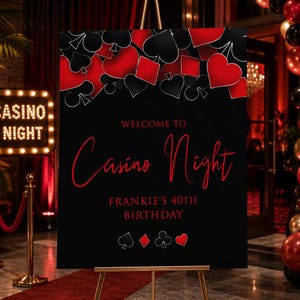 Może przedstawiać: Czarny znak na złotym sztaludze z czerwonymi i czarnymi symbolami kart do gry. Znak głosi "Welcome to Casino Night" i "Frankie's 40th Birthday" w czerwonym skrypcie. Tło to kasyno.