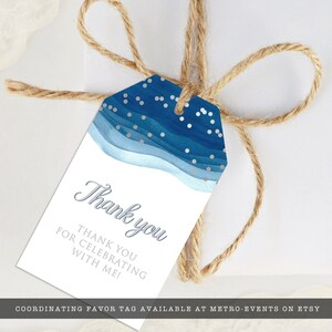May include: A white gift tag with a blue watercolor design and silver accents, tied with twine. The tag reads "Thank you" and "Thank you for celebrating with me!"