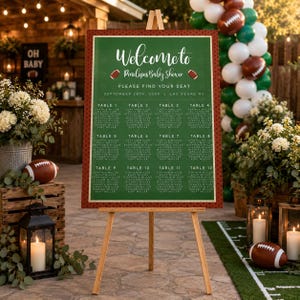 Può includere: Un cartello verde con il piano dei posti a sedere per un baby shower su un cavalletto in legno, con testo bianco che recita Welcome to Penelope's Baby Shower, Please Find Your Seat, September 28th, 20XX, Las Vegas NV, dodici tavoli e football.