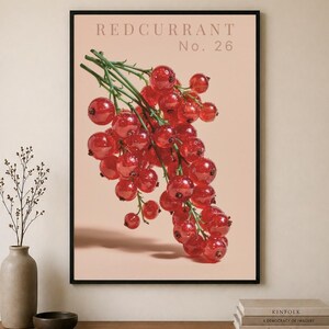 Może przedstawiać: Oprawiony wydruk przedstawiający kiść czerwonych porzeczek z napisem „REDCURRANT No. 26”. Czerwone owoce na zielonych łodygach na jasnym, brzoskwiniowym tle. Wydruk jest w czarnej ramie.