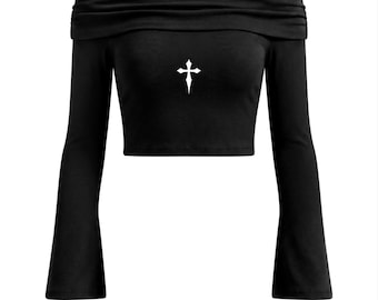 May include: Black off-the-shoulder crop top with long sleeves. The top has a white cross design on the front. The sleeves are flared at the wrist. The top is made of a soft, stretchy material.