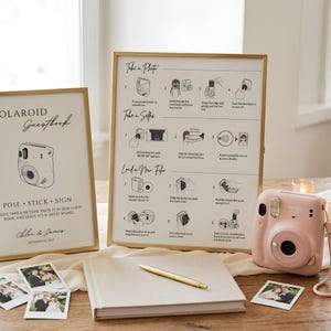 Puede incluir: Un letrero con marco dorado con instrucciones para un libro de visitas Polaroid, un letrero a juego con el texto Polaroid Guestbook, una cámara instantánea rosa claro, un libro de visitas beige, un bolígrafo dorado y fotos sobre madera.