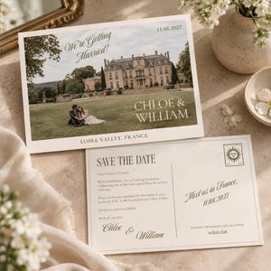 May include: A rectangular save the date card featuring a photo of a couple in front of a French chateau with the text We're Getting Married, Chloe & William, and 11.08.2027. The reverse side includes Save The Date text and a sun icon.