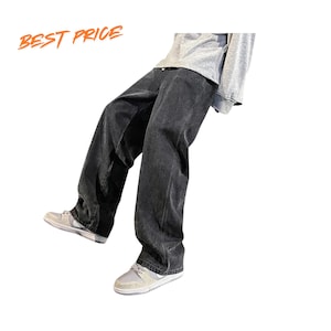May include: Loose-fitting charcoal black denim jeans with a wide-leg cut, paired with a light gray long-sleeve shirt and light-colored sneakers. The text BEST PRICE is visible in orange in the upper left corner of the image.