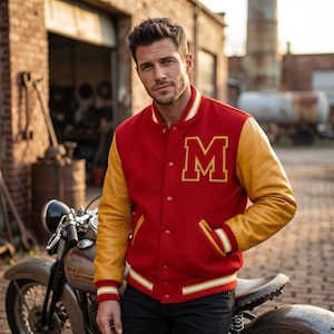 May include: A red varsity jacket with yellow sleeves and a large yellow letter M patch on the chest. The jacket features a snap-button front closure, ribbed cuffs, a ribbed collar, and a ribbed hem, all with white and yellow striped detailing.