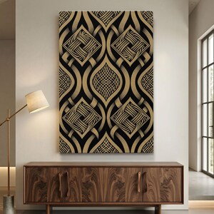 May include: A large rectangular canvas art piece with a repeating geometric pattern in black and gold. The design features interwoven shapes and square elements, creating a visually complex and textured appearance. The artwork is displayed on a wall above a wooden cabinet.