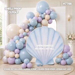 May include: A shell prop cutout measuring 4 feet wide by 4 feet tall, featuring a light blue scalloped design. It is displayed alongside a large balloon arch in shades of light blue, lavender, and cream, with the text H7788 visible.