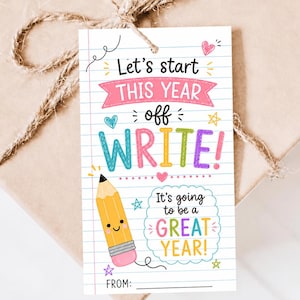Pode incluir: Uma etiqueta de presente retangular com um fundo de papel branco pautado apresentando o texto Let's start THIS YEAR off WRITE! e It's going to be a GREAT YEAR! com um lápis de desenho animado, corações coloridos, estrelas e uma linha FROM:.