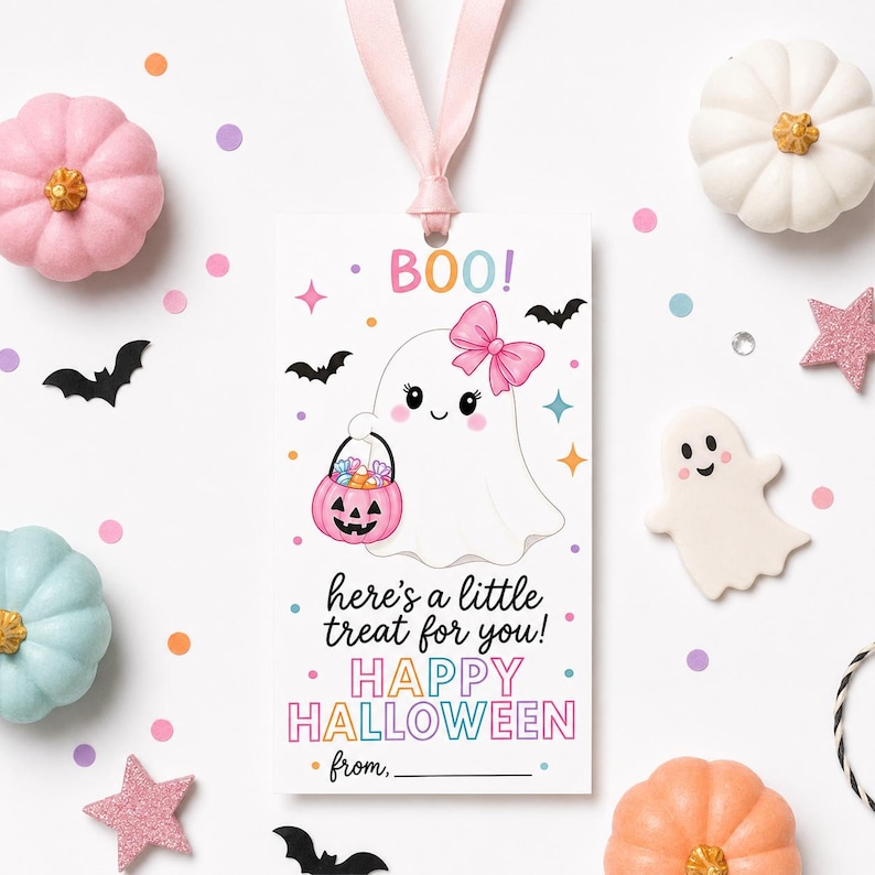 Puede incluir: Una etiqueta de regalo rectangular blanca con una cinta rosa que muestra un fantasma de dibujos animados sosteniendo un cubo de calabaza rosa lleno de dulces. El texto dice BOO!, here's a little treat for you!, HAPPY HALLOWEEN y from, con confeti.