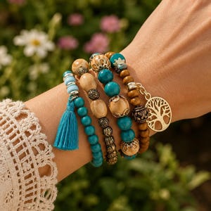 Puede incluir: Un conjunto de pulseras de varias hebras con cuentas de madera en tonos turquesa, azul claro y beige. El diseño incluye espaciadores metálicos con motivos florales, una borla de tela azul brillante y un dije circular dorado con una silueta de árbol.