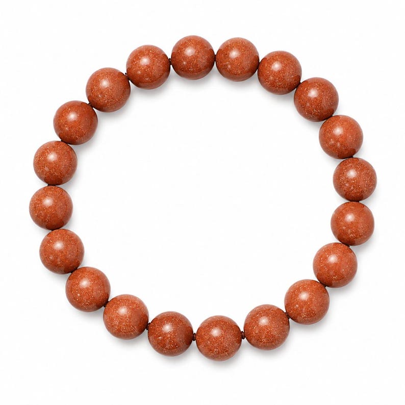 May include: A circular bracelet composed of nineteen spherical beads made of reddish-brown goldstone. Each bead features a smooth, polished surface with embedded metallic flecks that create a shimmering, glittery appearance throughout the material.