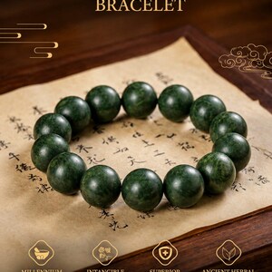 May include: A dark green beaded bracelet with spherical beads arranged in a circle. The text BOTANICAL SCENTED BRACELET appears at the top, with icons and text for MILLENNIUM INHERITANCE, INTANGIBLE CRAFT, SUPERIOR QUALITY, and ANCIENT HERBAL FORMULA below.
