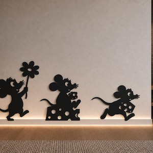 Könnte beinhalten: Drei schwarze Wand-Silhouetten von Cartoon-Mäusen. Die erste Maus hält eine Blume, die zweite sitzt auf einem Stück Schweizer Käse und die dritte rennt mit einem Stück Käse. Diese flachen, ausgeschnittenen Figuren sind in einer Reihe angeordnet.