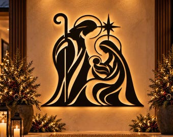 May include: A black metal wall art piece depicting a nativity scene with a shepherd, Mary, and the infant Jesus under a star. The silhouette is backlit with a warm glow, mounted on a light-colored wall above a stone porch entrance.