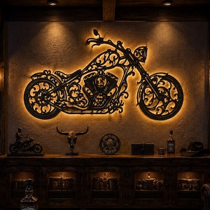 May include: A black metal wall art piece shaped like a motorcycle with intricate scrollwork, backlit by warm LED lighting. The wall art is mounted above a wooden console table in a room featuring signs that read RIDE HARD LIVE FREE and BIKER BY CHOICE.