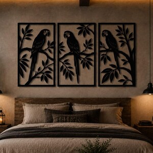 Puede incluir: Un conjunto de tres paneles de arte mural rectangulares de metal negro con siluetas de loros cortadas con láser posados en ramas frondosas. Cada panel muestra un motivo de ave detallado dentro de un marco limpio para montaje en pared.