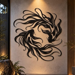 Pode incluir: Uma peça de arte de parede em metal preto com dois peixes estilizados com barbatanas longas e fluidas dispostos numa composição circular inspirada no yin-yang. O design recortado cria um efeito de silhueta na parede de cor clara.