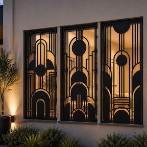 May include: Exterior of a building with three windows, each fitted with black Art Deco metal grilles. The grilles have a geometric design with circles and vertical lines. The windows are set in a light-coloured wall, with a small tree visible.