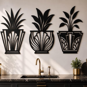 May include: Three black metal wall art pieces shaped like potted plants with geometric, fan-like patterns on the containers. Each piece features a distinct silhouette of foliage extending from the top of the decorative, structured planter base.