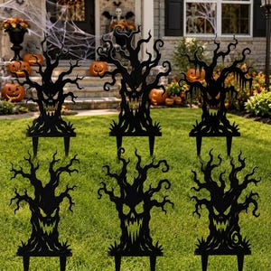 May include: A set of six black, flat, silhouette-style lawn stakes shaped like gnarled, spooky trees with jagged branches and menacing, carved-out facial features including sharp teeth and hollow eyes, each featuring two pointed prongs at the base.