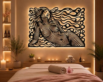 Puede incluir: Una pieza de arte mural negra que presenta una figura reclinada estilizada compuesta por líneas fluidas e intrincadas. El diseño está retroiluminado, creando un brillo cálido alrededor de los bordes del recorte, contrastando con el patrón lineal oscuro.