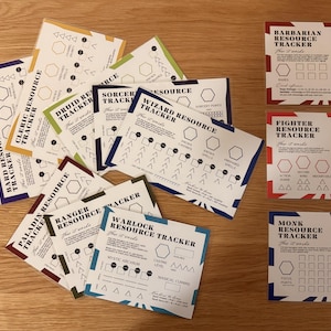 May include: A collection of rectangular paper resource tracker cards for tabletop role-playing games. Each card features a specific character class title, such as Wizard, Warlock, or Barbarian, with printed instructions, checkboxes, and geometric shapes for tracking game statistics and abilities.