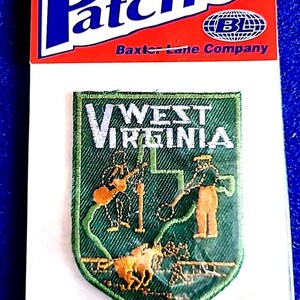 May include: An iron-on patch featuring the words "West Virginia" with a green and gold design. The patch includes images of a person, a horse, and a guitar player. The patch is on a white backing with a red and white "Patches" header.