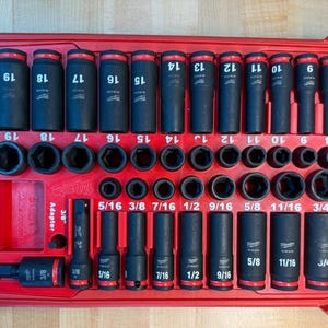 May include: A red toolbox containing a set of black impact sockets with red bands and white markings. The sockets are arranged in rows and include sizes from 7.9 mm to 19 mm. The toolbox also includes an adapter.