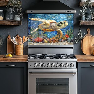 May include: A stainless steel gas range featuring a rectangular backsplash panel with a vibrant mosaic-style illustration of a sea turtle swimming underwater among colorful coral reefs and blue water textures, positioned in a kitchen setting.