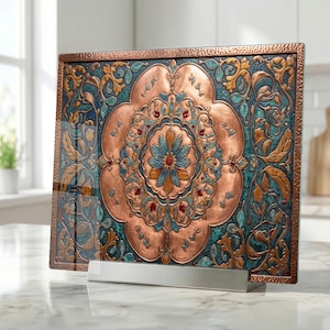 May include: A copper-colored decorative panel with an intricate floral design. The panel features a central flower with blue and orange petals, surrounded by teal and gold accents. The panel is displayed on a white stand, suitable for home decor.