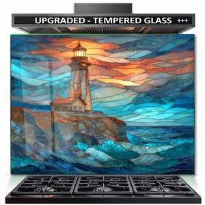 May include: A rectangular tempered glass kitchen backsplash panel featuring a stained glass style lighthouse scene with blue, orange, and yellow tones. The text UPGRADED - TEMPERED GLASS +++ is printed in white on a black bar at the top.