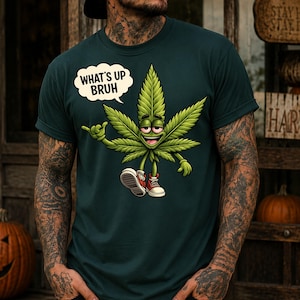 May include: Dark green t-shirt featuring a cartoon cannabis leaf character with red sneakers and a speech bubble that says "WHAT'S UP BRUH". The leaf has a smiling face and is giving a shaka sign.