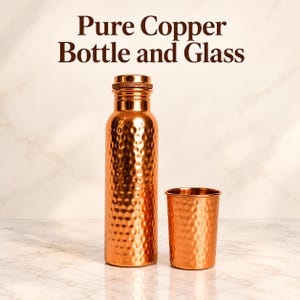 May include: A metallic copper bottle and a matching cup, both featuring a textured hammered finish. The bottle has a cylindrical body with a screw-top lid. The text "Pure Copper Bottle and Glass" is displayed in dark brown letters above the items.