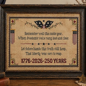 May include: Framed cross-stitch artwork with patriotic theme. The piece features an eagle, American flags, and text commemorating 250 years. The text reads "Remember well this noble year...1776-2026-250 YEARS." The frame is dark wood.