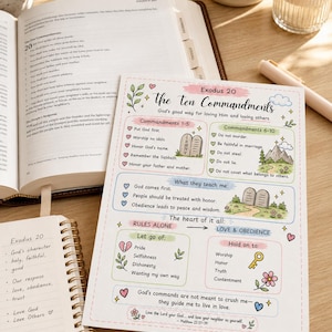 May include: A colorful, illustrated guide to the Ten Commandments, with text and graphics. The guide is on a wooden surface, next to an open Bible, a notebook, a pen, and a lit candle.