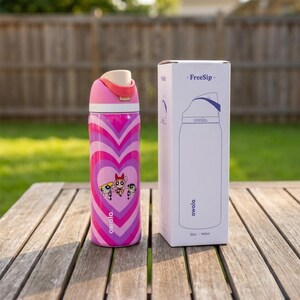 May include: A pink and purple insulated water bottle with a heart design and the Powerpuff Girls characters. The bottle has a pink lid and a white box with the text "FreeSip" and a bottle outline.