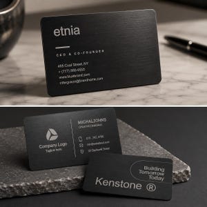 Könnte beinhalten: Drei rechteckige schwarze Metall-Visitenkarten mit gebürsteter Oberfläche. Die Karten zeigen weiß gedruckten Text, einschließlich Namen, Titeln, Kontaktinformationen und Firmenlogos wie etnia, Michal Johns und Kenstone mit dem Slogan Building Tomorrow Today.