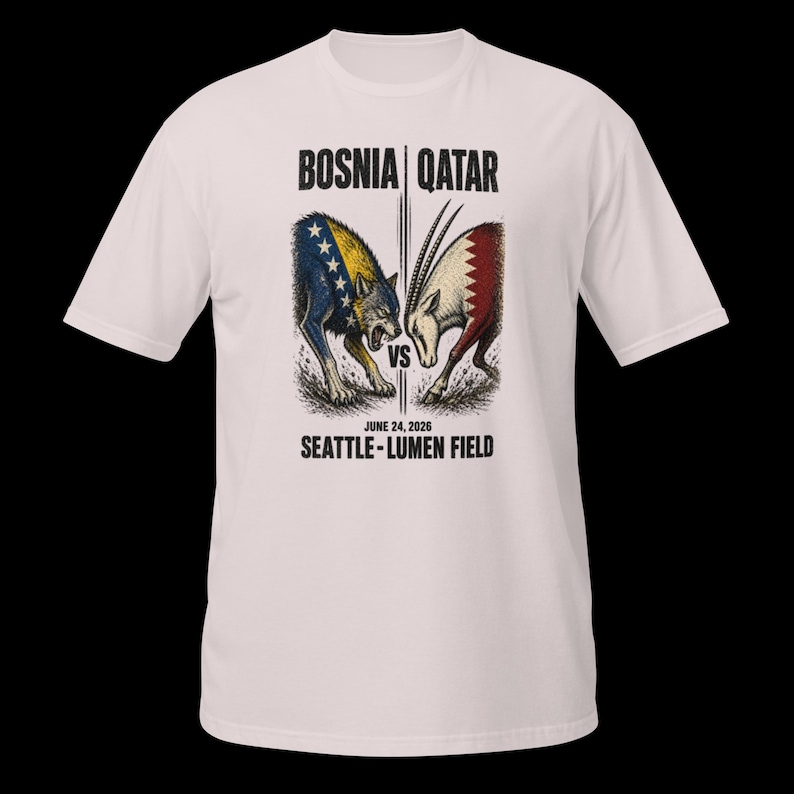 May include: White t-shirt with a graphic depicting a wolf and an oryx in a face-off, with the text "BOSNIA | QATAR" above and "JUNE 24, 2026 SEATTLE - LUMEN FIELD" below. The wolf is blue and yellow, the oryx red and white.